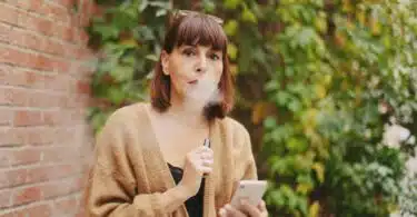 une femme vapotant à l'extérieur