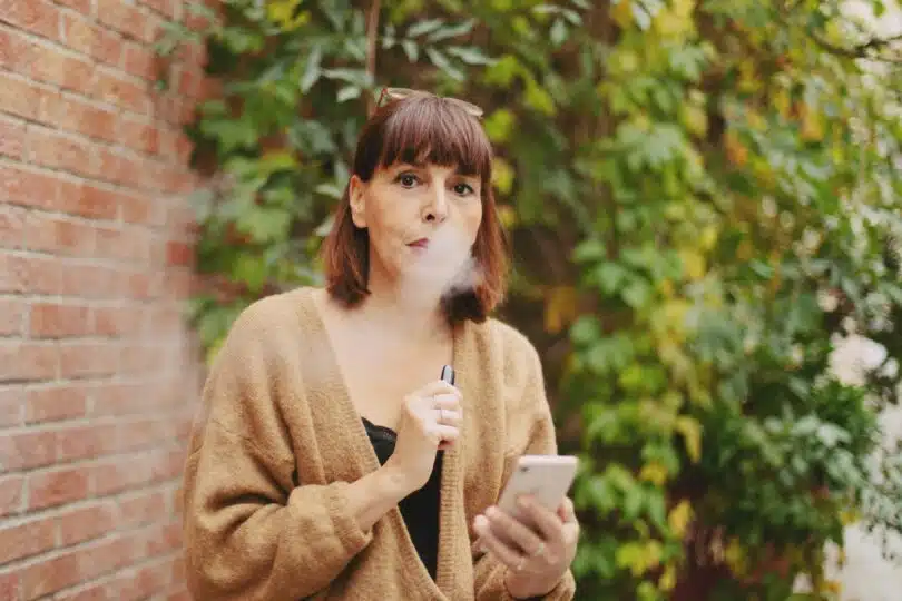 une femme vapotant à l'extérieur