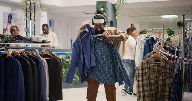 Un homme regarde de près des blazers dans le centre commercial.