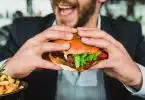un homme mangeant un burger