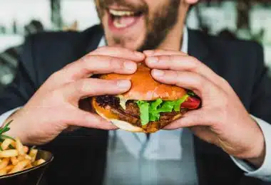 un homme mangeant un burger