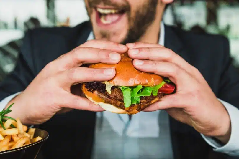 un homme mangeant un burger