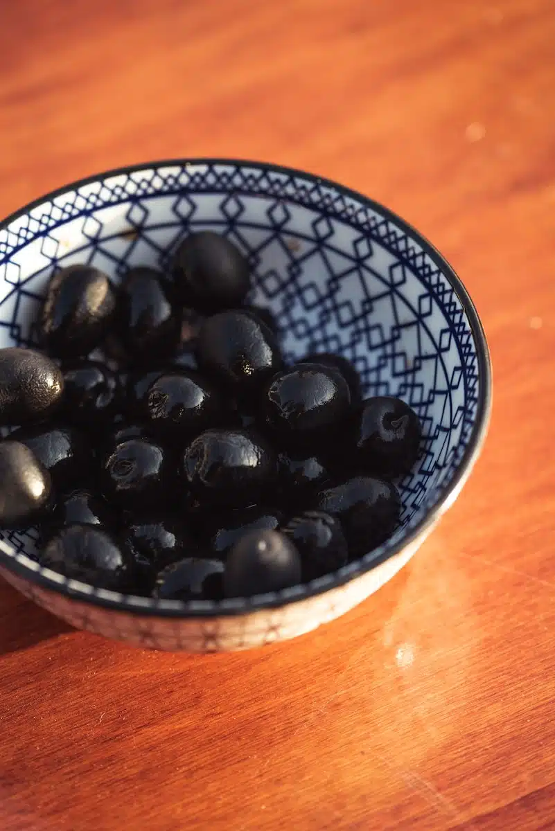 black round fruits on white and blue ceramic bowl